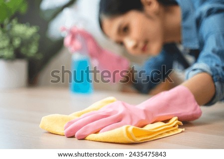Close-up hand of maid cleaning table during household job.