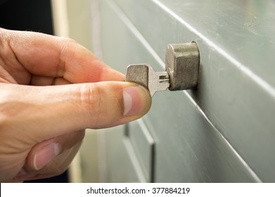 closeup of hand man is opening the cabinet with the key 