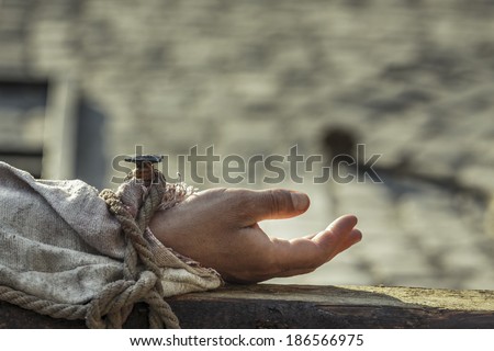 Closeup of hand nailed on wooden cross. Crucifixion of Jesus Christ.