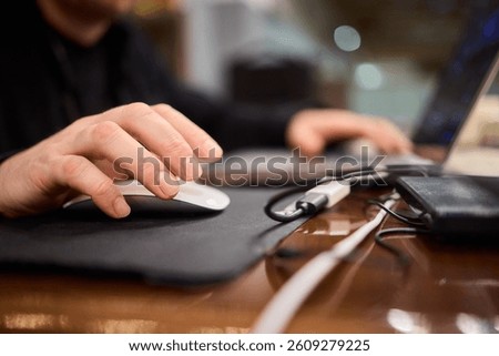 Closeup of a Hand on a Mouse While Effectively Working on a Laptop in a Modern Office