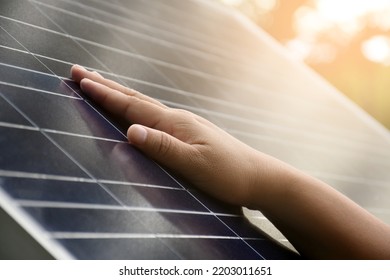 Closeup hand on photovoltaic or solar cell panel, soft and selective focus on hand, self photovoltaic panel checking by touch the surface, sustainable energy in human life concept. - Shutterstock ID 2203011651