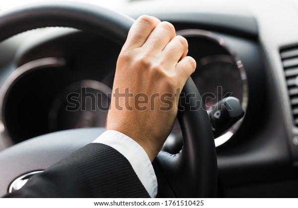 Close-up of a Hand on a\
Steering Wheel