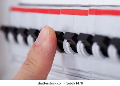 Close-up Of Hand On Switch Of Distribution Board