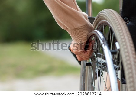Close-up of a hand on a wheelchair wheel. The concept of a wheelchair, disabled person, full life, paralyzed, disabled person, happy life