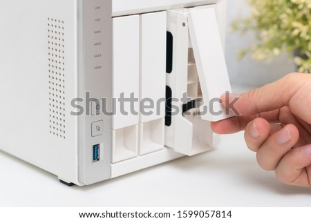Closeup, a man’s hand open one of drives arrays of personal NAS storage server and pull out hard disks to change in order to keep security, availability and accessibility of small business data.  Zdjęcia stock © 