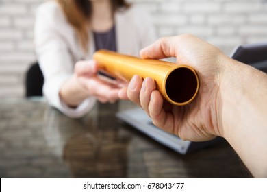 Close-up Of A Hand Passing Golden Relay Baton To Businesswoman