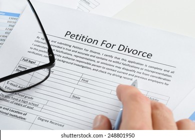 Close-up Of Hand With Pen On Petition For Divorce Paper