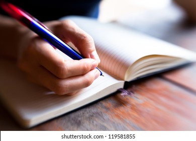 Close-up of hand pen writes in a notebook (blurred) - Powered by Shutterstock