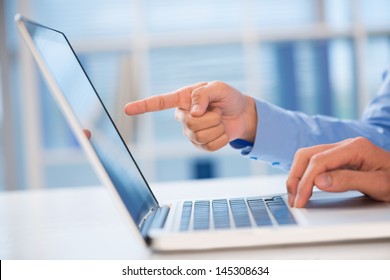 Close-up of a hand pointing something in the computer inside