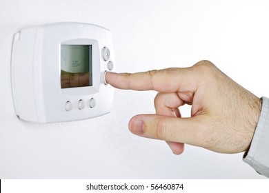 Closeup Of Hand Pressing Button On Digital Thermostat