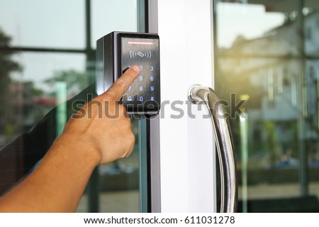 Close-up hand pressing keyword to lock and unlock door - Door access control keypad with keycard reader