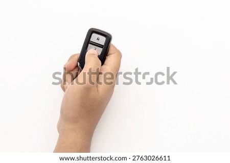 Close-up of a Hand Pressing the Unlock Button on a Black Car Key Fob
