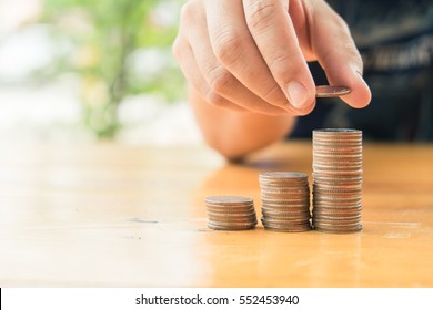 Closeup of hand put Coins to stack of coins,Concept Saving money. Saving money back car - Shutterstock ID 552453940