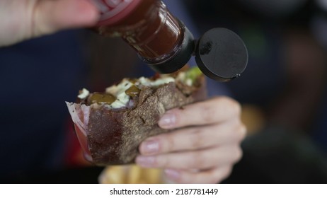 Closeup Hand Putting Ketchup Sauce On Burger. Person Adding Hot Sauce On Hamburger