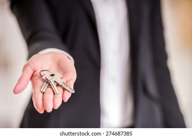 Close-up of hand of realtor woman is holding key.