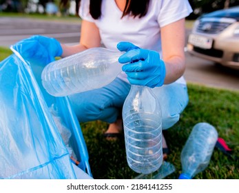 close-up of a hand in a rubber glove collects a plastic garbage bag. Cleaning the area from household waste. Environment ecology concept