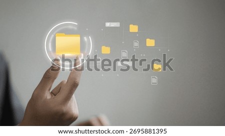 Close-up of hand selecting floating digital folder icon, representing file organization, metadata tagging, and content management for efficient cloud search, approval, and workflow.