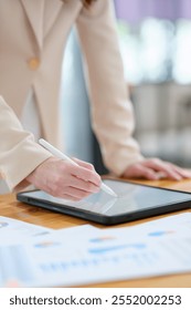 A close-up of a hand signing electronic documents on a tablet using a digital pen. The image highlights advanced technology for online signatures, data analysis, and creative digital workflows.