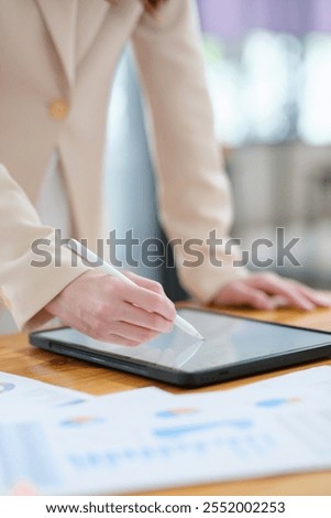 A close-up of a hand signing electronic documents on a tablet using a digital pen. The image highlights advanced technology for online signatures, data analysis, and creative digital workflows.