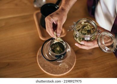 Close-up Of A Hand, Someone Putting A Dried Herb Into The Teapot, Making A Tea.