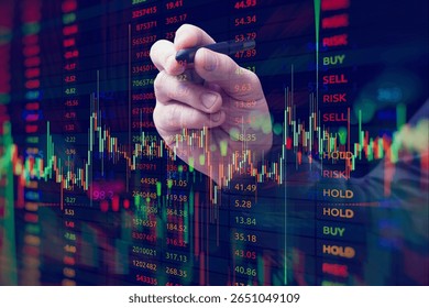 A close-up of a hand with a stylus interacting with a digital stock market chart. The overlay of candlestick graphs, buy and sell signals and numerical data