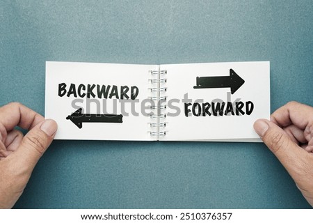 Closeup hand taking an opened notepad on the desk, make a decision to turn the page forward or backward