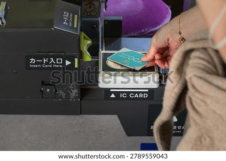 close-up of hand tapping ic card on transport gate scanner in japan