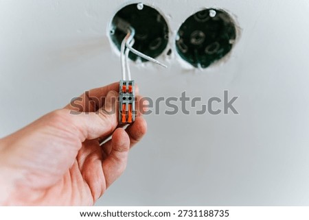 CloseUp Hand Testing Connection Inside Wall, Inspector Performing Precision Check On PushIn Connector With Focus On Grounding And Protection, Scene Suggests Renovation Quality Control And Compliance