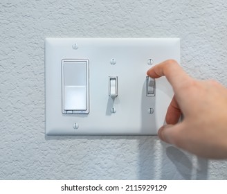 Closeup Hand Turning On-off Switch After Using, Saving Energy Concept. Minimal Design Of Mounted Electricity Control On The Wall. Household Electric Outlet In Home, Residential, Indoor Room, Apartment