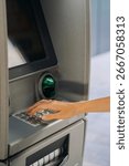 Close-up of a woman’s hand typing a PIN code on the keypad of an ATM cash machine. Concept of banking, finance, money withdrawal, personal security, cashless payments, and modern financial services.