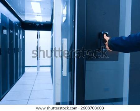 A close-up of a hand using an access control system to enter a modern data center, showcasing advanced security technology and infrastructure management.