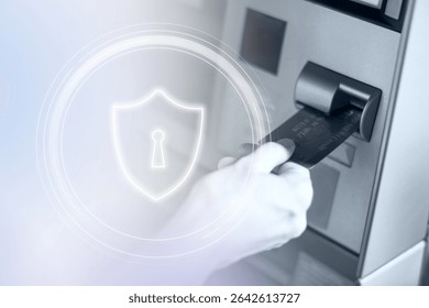 Close-up of a hand using an ATM card, highlighting ATM security, ATM card and security symbol emphasize secure transactions at ATMs. High-tech technology photo showing data for futuristic technology.