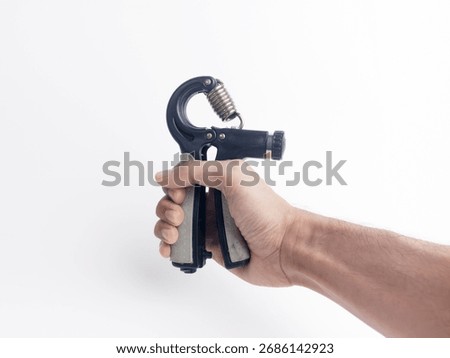 Close-up of hand using a hand gripper exercise tool. Fitness equipment for strength training arm and forearm muscles. Isolated on white background.
