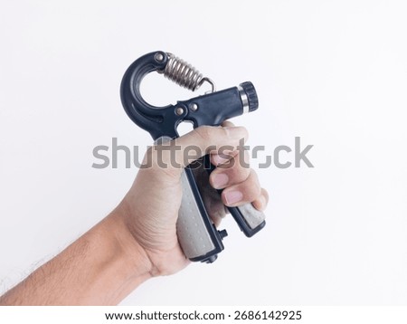Close-up of hand using a hand gripper exercise tool. Fitness equipment for strength training arm and forearm muscles. Isolated on white background.
