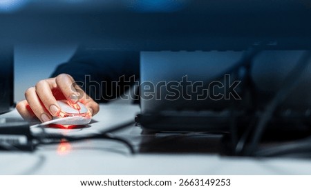 Close-up of a hand using a mouse. Blurred image with detail of a hand using a mouse. Technology and internet concept.