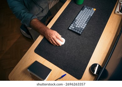 Close-up of hand using mouse on desk mat.