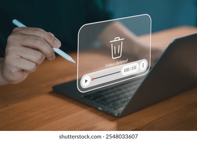 A close-up of a hand using a pen on a laptop with a virtual overlay displaying a "video deleted" message, symbolizing digital file management and deletion. - Powered by Shutterstock - Get 15% off with code: PIKWIZARD15