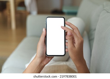 close-up hand using phone showing white screen in living room - Shutterstock ID 2197838001