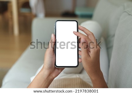 close-up hand using phone showing white screen in living room