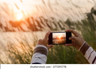 closeup hand using phone similar to iphone6 style taking landscape photo