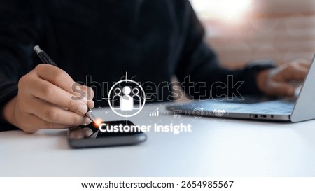 Close-up of a hand using a smartphone with a customer insight icon, representing digital marketing analytics, consumer behavior analysis, CRM strategy, and personalized business targeting.
