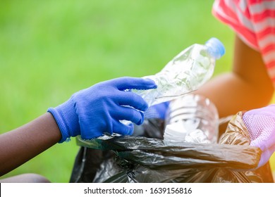 Close-up Of Hand Volunteer Charity Environment, Hand Of Kids Collecting Garbage Into A Black Bag.