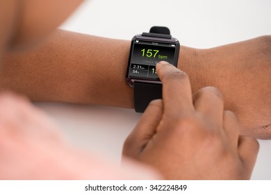 Close-up Of Hand Wearing Smartwatch Showing Heartbeat Rate - Powered by Shutterstock