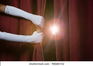 Close-up of hand in a white glove pulling curtain away - Shutterstock ID 700685722