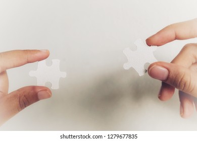 Closeup hand of woman connecting jigsaw puzzle with sunlight effect, Business solutions, success and strategy concept - Image - Shutterstock ID 1279677835