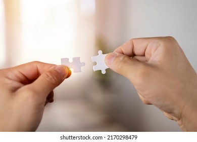 Closeup Hand Of Woman Connecting Jigsaw Puzzle With Sunlight Effect, Business Solutions, Success And Strategy Concept