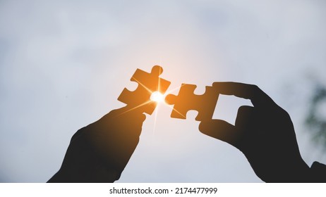 Closeup Hand Of Woman Connecting Jigsaw Puzzle With Sunlight Effect, Business Solutions, Success And Strategy Concept