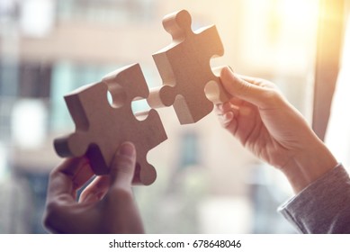Closeup hand of woman connecting jigsaw puzzle with sunlight effect, Business solutions, success and strategy concept