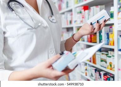Closeup hand of woman pharmacist with prescription and medicine at drugstore