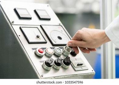 Close-up Of The Hand Of A Woman Wearing White Lab Coat, While Turning On An Industrial Machine With Mechanical Key-operated Switch During Work In A Factory